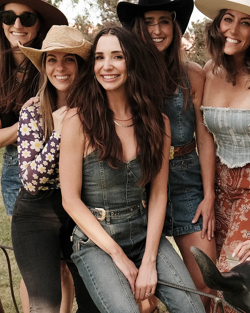 Photo of Blaine in a jean outfit, surrounded by friends, smiling