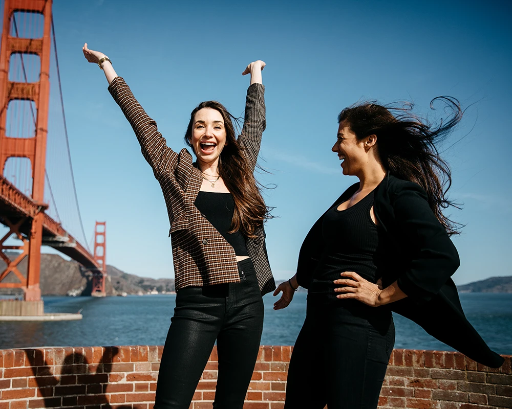 Me and Tara in front of the Golden Gate bridge, hands up, smiling